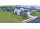 Charming two-story house with a well-manicured lawn and a pristine driveway leading to an attached garage at 445 Waterfern Trail Dr, Auburndale, FL 33823