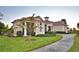 A well maintained single-story home with manicured landscaping, mature trees, and a paved driveway at 445 Waterfern Trail Dr, Auburndale, FL 33823
