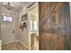 Hallway with a wooden sliding door leading to a bedroom or office space filled with natural light at 445 Waterfern Trail Dr, Auburndale, FL 33823