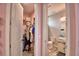 Hallway view into pink bedroom and bathroom featuring doors to closet and bathroom at 445 Waterfern Trail Dr, Auburndale, FL 33823