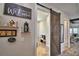 Hallway with decor shelves, a welcome sign, and a rustic sliding barn door that offers a warm, inviting entrance at 445 Waterfern Trail Dr, Auburndale, FL 33823