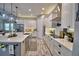 Updated kitchen with white cabinets, stainless steel appliances, a center island and wood-look tile flooring at 445 Waterfern Trail Dr, Auburndale, FL 33823