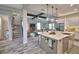Open-concept kitchen with island, farmhouse sink, and barstool seating flowing into the living room and staircase at 445 Waterfern Trail Dr, Auburndale, FL 33823