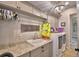 Functional laundry room showcasing a sink, granite countertops, cabinetry, modern appliances, and stylish decor at 445 Waterfern Trail Dr, Auburndale, FL 33823