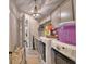 Well-equipped laundry room featuring a washer, dryer, storage cabinets, and decorative lighting at 445 Waterfern Trail Dr, Auburndale, FL 33823