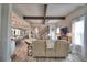 Open concept living room boasts hardwood floors, decoratively framed stairs and an entertainment center, flowing into the kitchen at 445 Waterfern Trail Dr, Auburndale, FL 33823