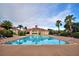 A community pool with ample seating surrounded by palm trees and overlooking the clubhouse at 445 Waterfern Trail Dr, Auburndale, FL 33823