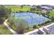 Aerial view of tennis and basketball courts surrounded by green spaces and walking path at 445 Waterfern Trail Dr, Auburndale, FL 33823