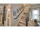 Carpeted staircase featuring a dark wood railing and decorative wall art at 445 Waterfern Trail Dr, Auburndale, FL 33823