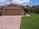Charming home features a brick driveway, two-car garage, and well-maintained landscaping at 4488 Turnberry Ln, Lake Wales, FL 33859