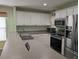 Functional kitchen layout featuring white cabinets, stainless steel appliances, and a convenient countertop for casual dining at 4488 Turnberry Ln, Lake Wales, FL 33859