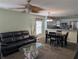 Inviting living room area featuring a comfortable black sofa, a unique glass-top coffee table, and an adjacent dining area at 4488 Turnberry Ln, Lake Wales, FL 33859