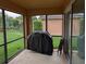 Enclosed outdoor patio with large screened windows and sliding doors, complete with furniture and a grill at 4488 Turnberry Ln, Lake Wales, FL 33859