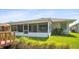 Backyard with a screened-in porch with outdoor seating and a flourishing lawn at 469 Sweetwater Way, Haines City, FL 33844