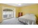 Bedroom showcasing a comfy bed and natural light from large, arched window at 469 Sweetwater Way, Haines City, FL 33844