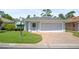 Charming single-story home featuring a brick driveway and manicured lawn at 469 Sweetwater Way, Haines City, FL 33844