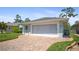 View of the home with brick driveway leading to a screened two-car garage at 469 Sweetwater Way, Haines City, FL 33844