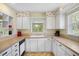 Bright kitchen featuring white cabinets, neutral countertops, and view of the backyard at 469 Sweetwater Way, Haines City, FL 33844