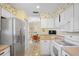 Traditional kitchen with stainless steel refrigerator, white cabinets, and view to the dining room at 469 Sweetwater Way, Haines City, FL 33844