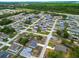 Expansive aerial view showcases a well-planned residential neighborhood with tree-lined streets and neatly arranged homes at 47 Willow Ln, Kissimmee, FL 34759