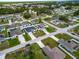 Aerial view of a neighborhood with houses, green spaces, and tree-lined streets at 47 Willow Ln, Kissimmee, FL 34759