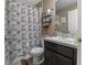 Cozy bathroom features leaf-patterned shower curtain, brown cabinets, and modern fixtures at 47 Willow Ln, Kissimmee, FL 34759