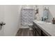 Bright bathroom with decorative shower curtain, wood-look flooring, and gray countertop at 47 Willow Ln, Kissimmee, FL 34759