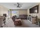 Cozy living room featuring comfortable seating, a ceiling fan, and a large TV at 47 Willow Ln, Kissimmee, FL 34759