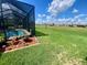 Well-maintained backyard with lush grass and tropical landscaping and partial pool view at 5005 Pebble Beach Blvd, Winter Haven, FL 33884
