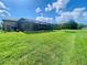 Expansive backyard with lush lawn and screened-in lanai, offering ample space for outdoor activities and relaxation at 5005 Pebble Beach Blvd, Winter Haven, FL 33884