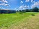 Lovely backyard featuring a screened patio, mature landscaping, and sunny skies at 5005 Pebble Beach Blvd, Winter Haven, FL 33884