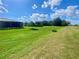 Spacious green backyard with a screened lanai, young tree, and neat landscaping, creating a serene outdoor space at 5005 Pebble Beach Blvd, Winter Haven, FL 33884
