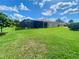 Landscaped backyard featuring a screened lanai, offering privacy and a comfortable outdoor living space at 5005 Pebble Beach Blvd, Winter Haven, FL 33884