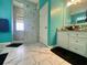 Bright bathroom with marble floors, standing shower, and a vanity with sink at 5005 Pebble Beach Blvd, Winter Haven, FL 33884