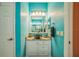 Bathroom with turquoise walls, vanity with vessel sink and decorative lighting at 5005 Pebble Beach Blvd, Winter Haven, FL 33884