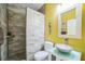 Bathroom showcasing gray tiled shower, toilet, vanity, and yellow walls at 5005 Pebble Beach Blvd, Winter Haven, FL 33884