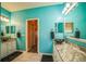 Turquoise primary bathroom with dual vanities and luxurious marble flooring at 5005 Pebble Beach Blvd, Winter Haven, FL 33884