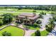 Exterior view of the clubhouse featuring manicured landscaping, and a covered patio for relaxing at 5005 Pebble Beach Blvd, Winter Haven, FL 33884