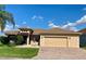Inviting home exterior features lush landscaping, a decorative fountain, and a brick driveway, enhancing curb appeal at 5005 Pebble Beach Blvd, Winter Haven, FL 33884