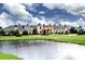 Grand mansion-style building overlooking pond, with lush landscaping and elegant architectural details creating an upscale setting at 5005 Pebble Beach Blvd, Winter Haven, FL 33884