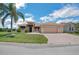 Beautiful single-story home with a palm tree, landscaped lawn, decorative fountain, and a brick-paved driveway leading to an attached garage at 5005 Pebble Beach Blvd, Winter Haven, FL 33884