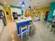 Open kitchen with an island with seating, flowing into the dining and living areas at 5005 Pebble Beach Blvd, Winter Haven, FL 33884