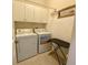 Cozy laundry room equipped with washer, dryer, and overhead cabinets at 5005 Pebble Beach Blvd, Winter Haven, FL 33884