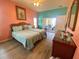 Well-lit main bedroom features wood floors, patio access, and tropical decor at 5005 Pebble Beach Blvd, Winter Haven, FL 33884