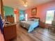 Spacious main bedroom boasts wood floors, wicker furniture, and plenty of natural light at 5005 Pebble Beach Blvd, Winter Haven, FL 33884