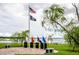 Veterans memorial featuring flags, granite markers, and lakeside view offering space for reflection and remembrance at 5005 Pebble Beach Blvd, Winter Haven, FL 33884
