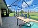 Screened in patio features hot tub with lounge chairs and large backyard at 5005 Pebble Beach Blvd, Winter Haven, FL 33884