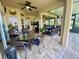 Expansive screened in patio features seating area and large ceiling fan at 5005 Pebble Beach Blvd, Winter Haven, FL 33884