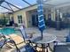 Covered patio with seating area, grill, and view of the screened in pool at 5005 Pebble Beach Blvd, Winter Haven, FL 33884