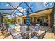 Relaxing screened-in patio with pool access, dining table, and comfortable seating area for outdoor living at 5005 Pebble Beach Blvd, Winter Haven, FL 33884